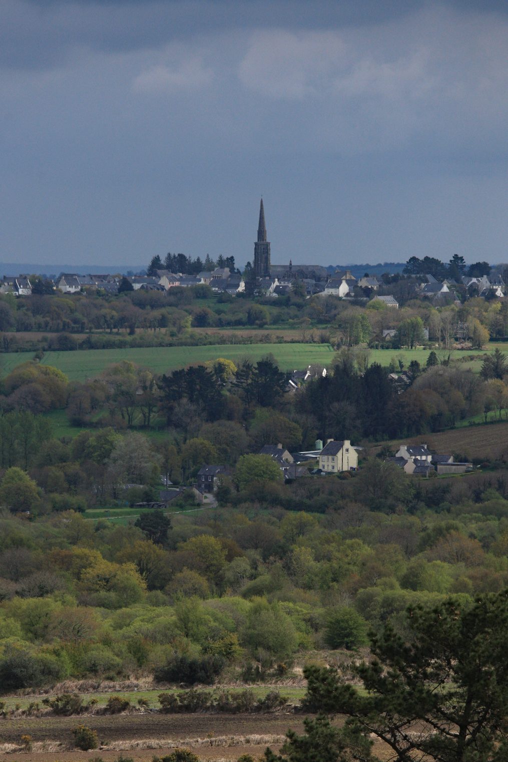 Vue de Commana avec l'allée couverte visible juste à gauche des maisons